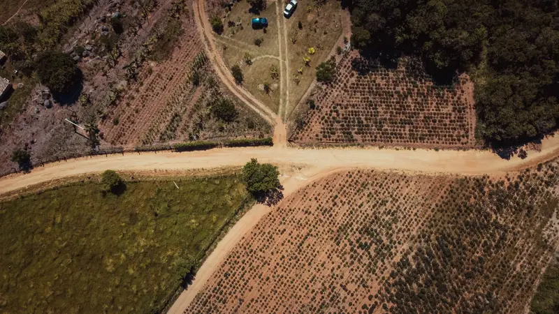 Vista aérea de áreas rurais com formatos diferentes, separadas por estradas de terra